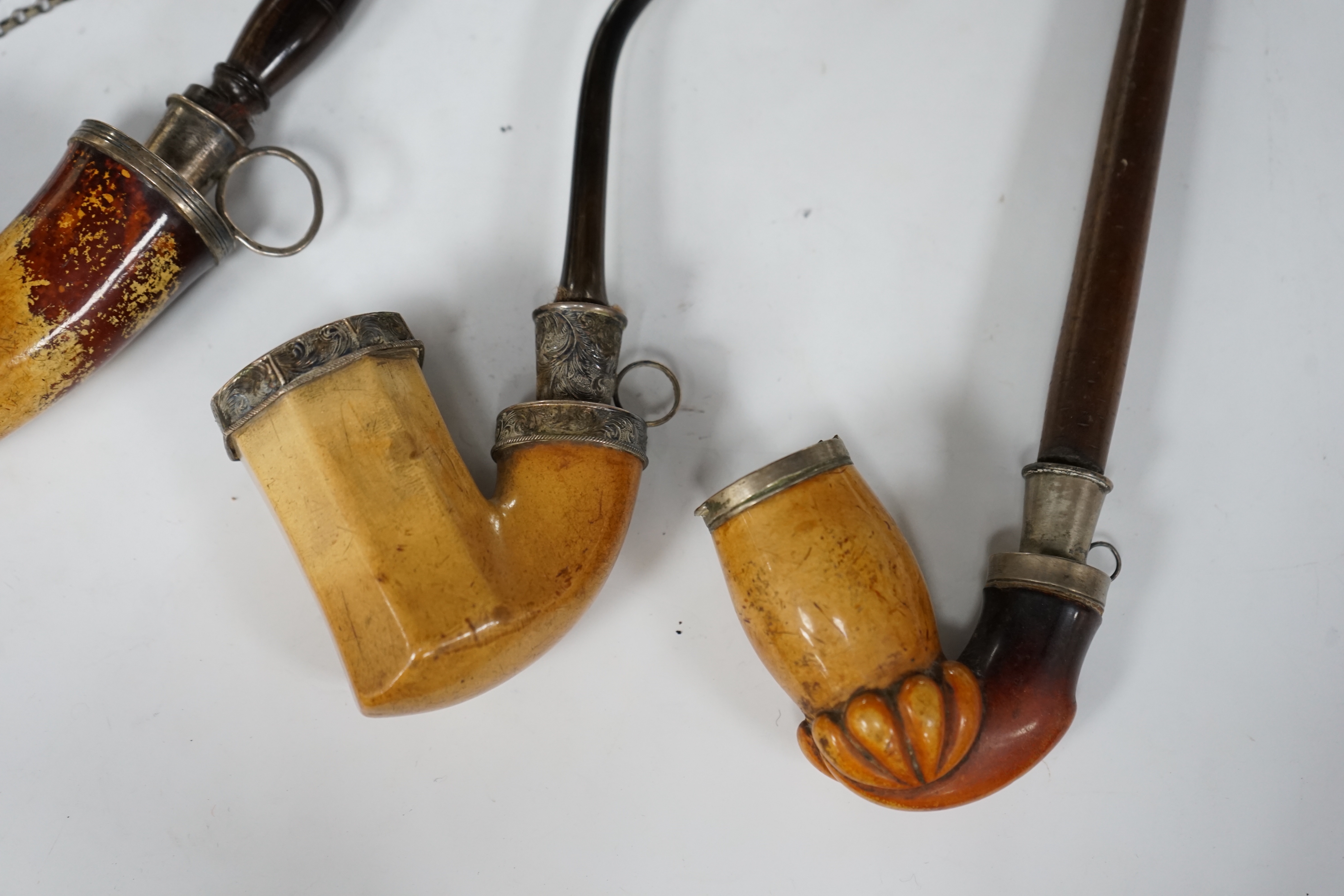 Four early Meerschaum pipes of varying sizes, largest 41cm high